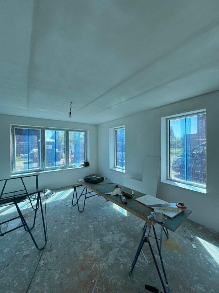 Nieuwbouwwoning met glad gestucte wanden en plafond tijdens de afbouw