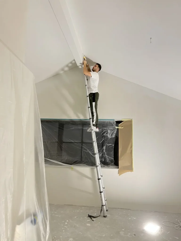 Stukadoor werkt een hoog plafond af