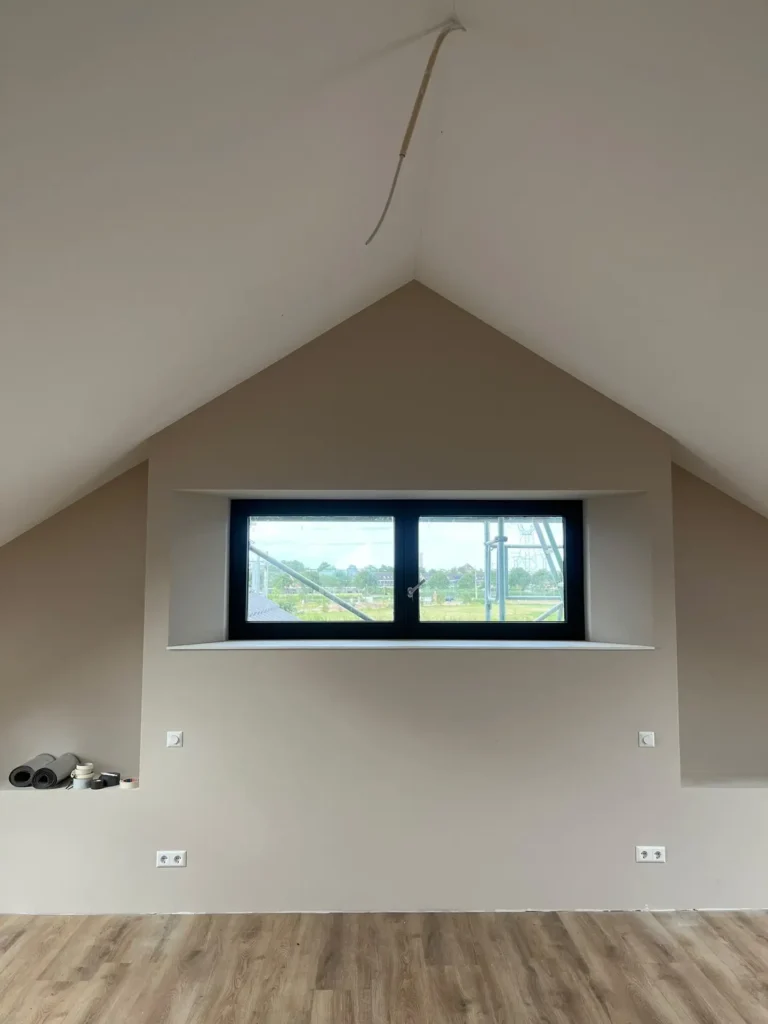 Glad sausklaar stucwerk bij een schuin plafond